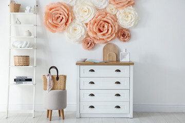 Beautiful decorative paper flowers on wall in room