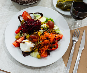 Healthy dish salad with fresh cheese, beetroot, greens and balsamic sauce on white plate