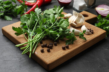 Fresh parsley and spices on black table, closeup