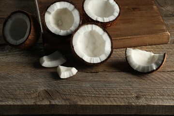 Pieces of cracked coconuts on wooden table