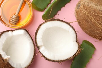 Hair treatment. Fresh coconut, honey and aloe leaves on pink background, flat lay