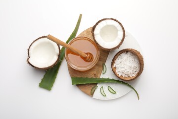 Hair treatment. Coconuts, butter shavings, honey and aloe leaves on white background, flat lay