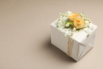 Florist. Box with flowers on light grey background, closeup. Space for text