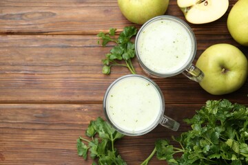 Healthy parsley drink in glasses, leaves and apples on wooden table, flat lay. Space for text