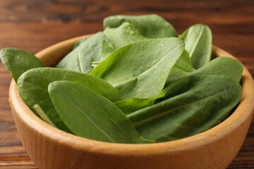 Fresh green sorrel leaves in bowl on table, closeup