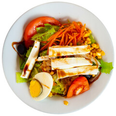 Delicious fresh vegetable salad served with tomatoes cheese and eggs on plate. Isolated over white background