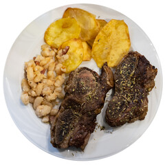 Grilled beef with spices and herbs with potatoes and beans on a white plate. Meat dish according to a traditional Spanish recipe. Isolated over white background