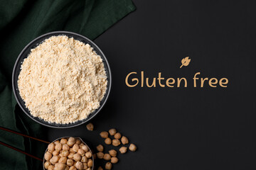 Gluten-free chickpea flour in bowl on black table, top view