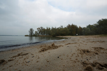 Serene beach view with gentle waves lapping against the shore at a tranquil riverside location...