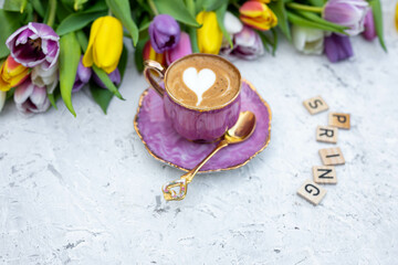 Beautiful spring background. Cup with coffee with tulips. Tulips background.