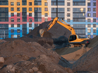 A crawler excavator on construction site, a building on the background