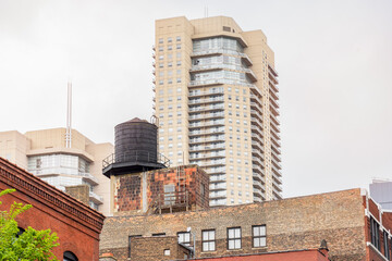 Traditional black water tank on the roof of an old brick building in downtown Chicago. A modern...