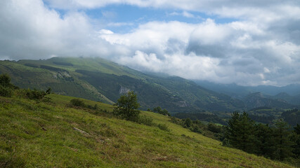 Fototapeta premium Rolling green hills stretch across the landscape in northern Spain.