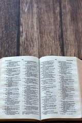 Fototapeta premium Open holy bible book on wooden background. Top view. Copy space. Christian study and reading, biblical concept.