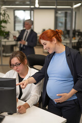 Fototapeta premium Caucasian pregnant woman giving instructions to subordinate in office. Vertical photo. 
