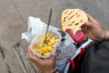 Colombian woman with plastic container, where she has her food.
