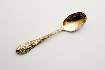 Ornate gold spoon with floral design, elegant and decorative, isolated on white background.