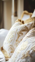Luxurious white pillows with gold embroidery, soft and elegant bedding details.