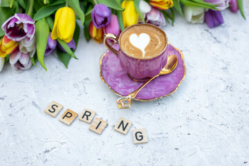 Beautiful spring background. Cup with coffee with tulips. Tulips background.