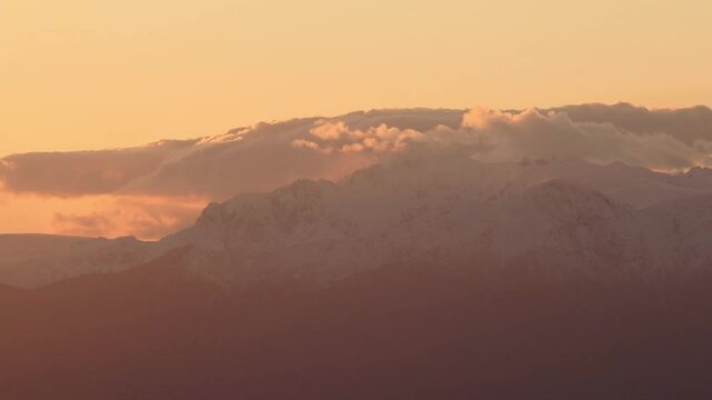 Time lapsed Lines of mountains on the horizon with orange and cyan blue colors