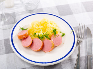 Boiled sausages frankfurter with mashed potato slices are served on plate. Traditional European breakfast