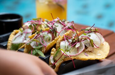 Chef placing gourmet tacos on serving tray by the pool in merida, yucatan