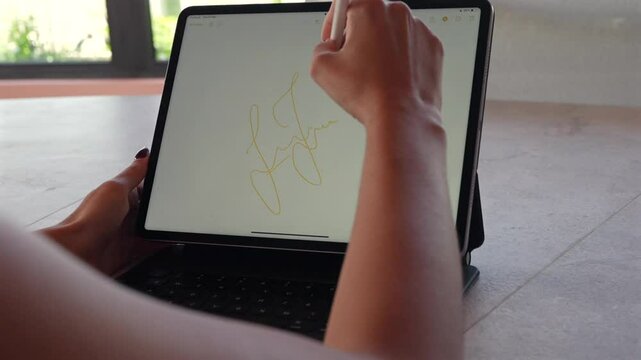 Mujer joven escribiendo en una tablet con un lapiz digital