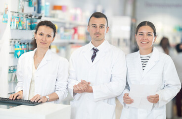 Fototapeta premium Three friendly pharmacists are ready to greet visitors to the pharmacy