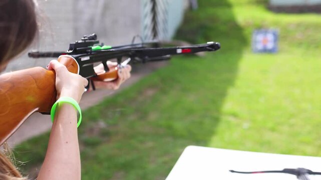 Crossbow shooting and archery at the shooting range, women and men practicing with arbalest at shooting gallery, compound bow training, aiming the target with arbalest at archery range, bow and arrows