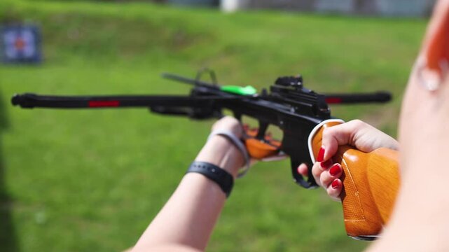 Crossbow shooting and archery at the shooting range, women and men practicing with arbalest at shooting gallery, compound bow training, aiming the target with arbalest at archery range, bow and arrows