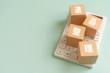 Obraz premium 遺品整理と書かれたブロックと電卓