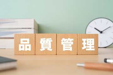 品質管理と書かれたブロックが置かれたデスク