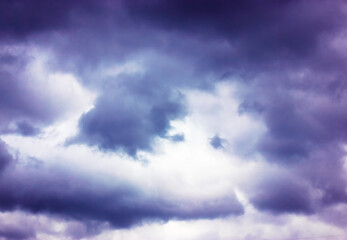 Dramatic overcast sky with heavy dark blue violet clouds. Twilight, evening time. Meteorology forecast warns of rain. Heavy clouds in the air.