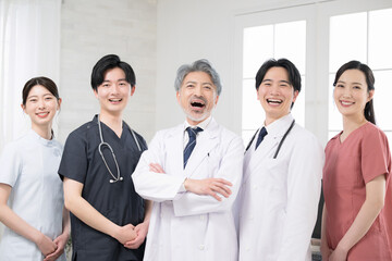 Fototapeta premium Image of a doctor with cool grey hair and multiple doctors, smiling, looking at the camera, big smile, success, etc.