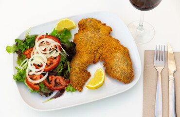 Breaded veal fillet with fresh vegetables, onions, tomatoes