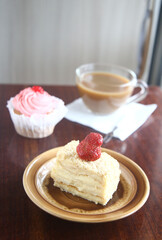 strawberry cake on a plate and cup of coffee