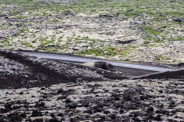 Road crossing volcanic landscape in Iceland near Grabrok crater
