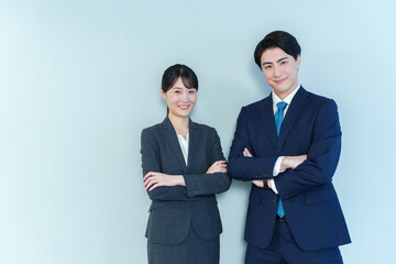 腕組みをするビジネスパーソン　ブルーバック