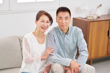 シニアの夫婦　ポートレート　リビング　カメラ目線