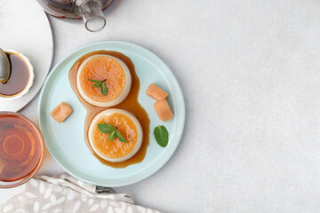 Tasty puddings with caramel sauce served on white table, flat lay. Space for text
