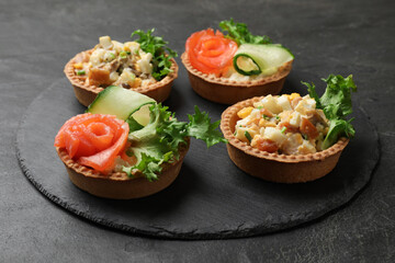 Tartlets with delicious fillings on black table, closeup