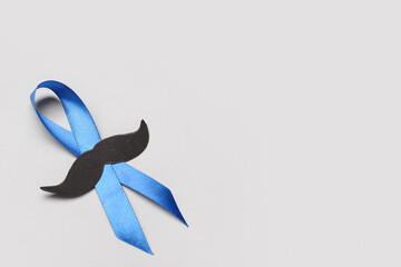 Blue awareness ribbon with paper mustache on grey background