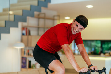 A triathlete riding a triathlon bike on a machine simulation in a modern living room
