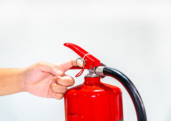 Naklejka premium Close up hands pulling safety pin of fire extinguisher.