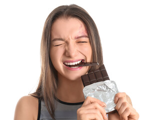 Young woman eating chocolate bar on white background