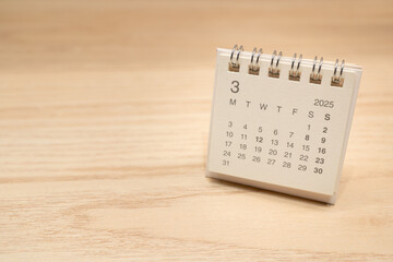 Desk Calendar for MARCH 2025 background. Calendar concept with 2025 MAR calendar on wooden...