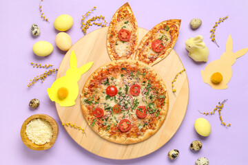 Board of tasty Easter pizza with bunny ears, eggs, cheese and mimosa branches on lilac background