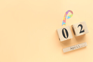 Calendar and awareness ribbon on beige background. Autism disorder concept