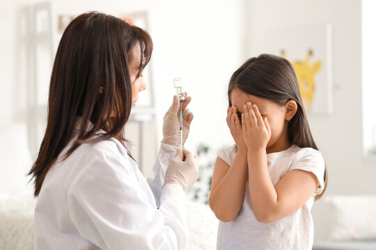 Scared little Asian girl receiving vaccine at hospital - Powered by Adobe