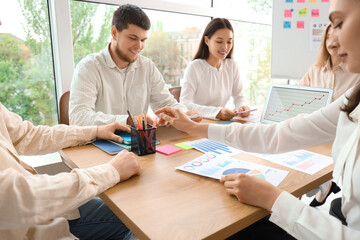 Business people with diagrams working on marketing plan in office
